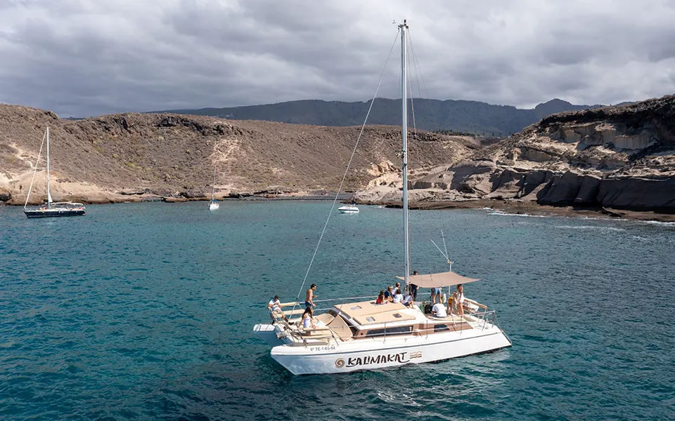 Imagen de un catamarán visto desde dron navegando por el océano Atlántico en Tenerife con varios pasajeros a bordo